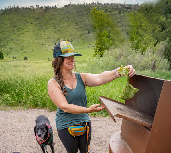Woman throwing dog waste away